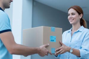Cliente recebendo encomenda de entregador em casa com sorriso de satisfação
