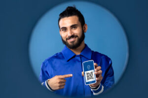 Homem sorridente mostrando QR Code de pagamento Pix no celular